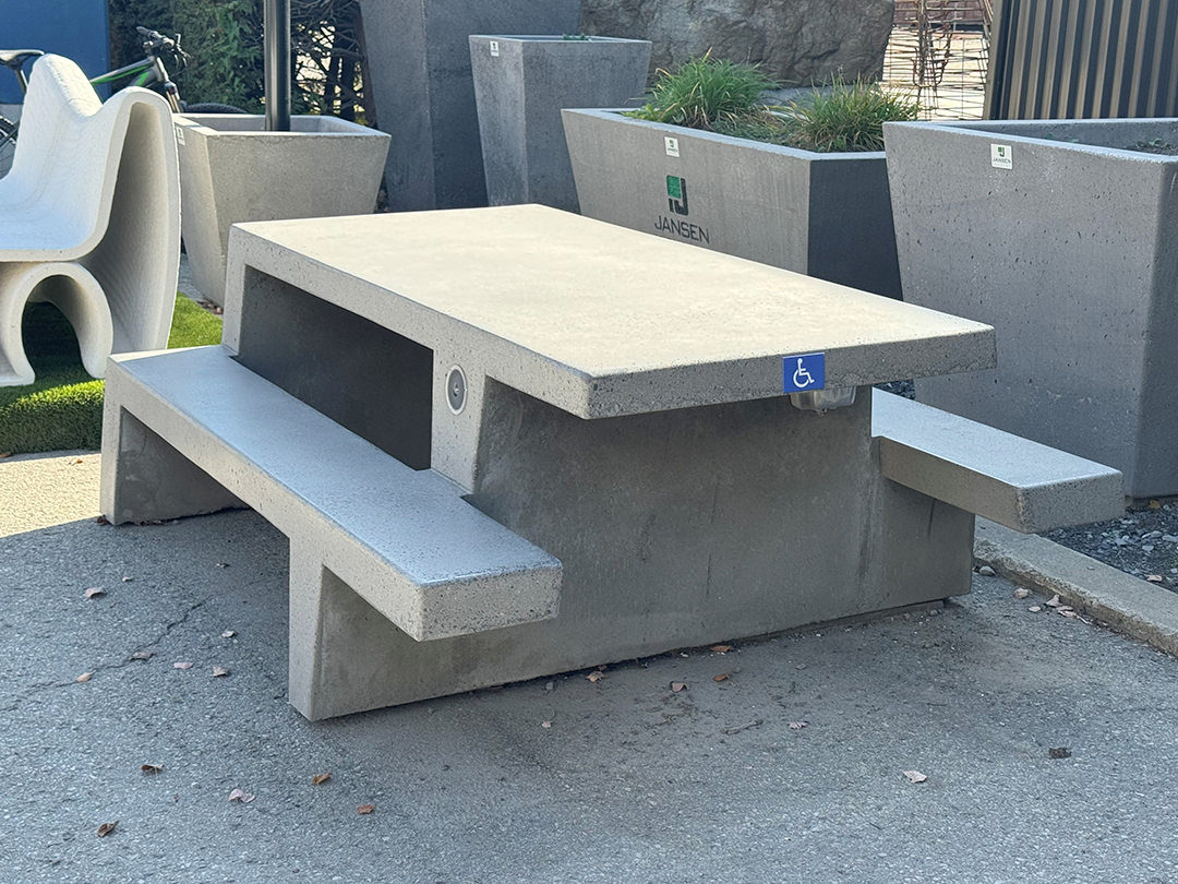 Angled view of Jansen Concrete picnic table showcasing minimalist, durable design for outdoor use.