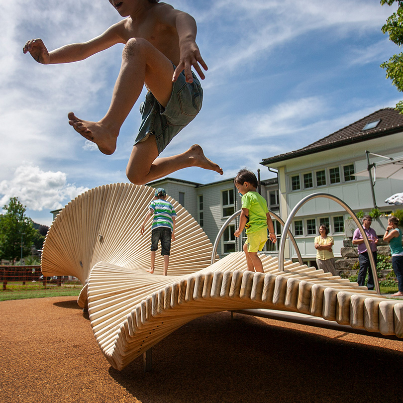 child leaping off a move art play sculpture